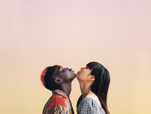 Two women chin-to-chin looking up with bright purple and red NOZ sunscreen on their noses